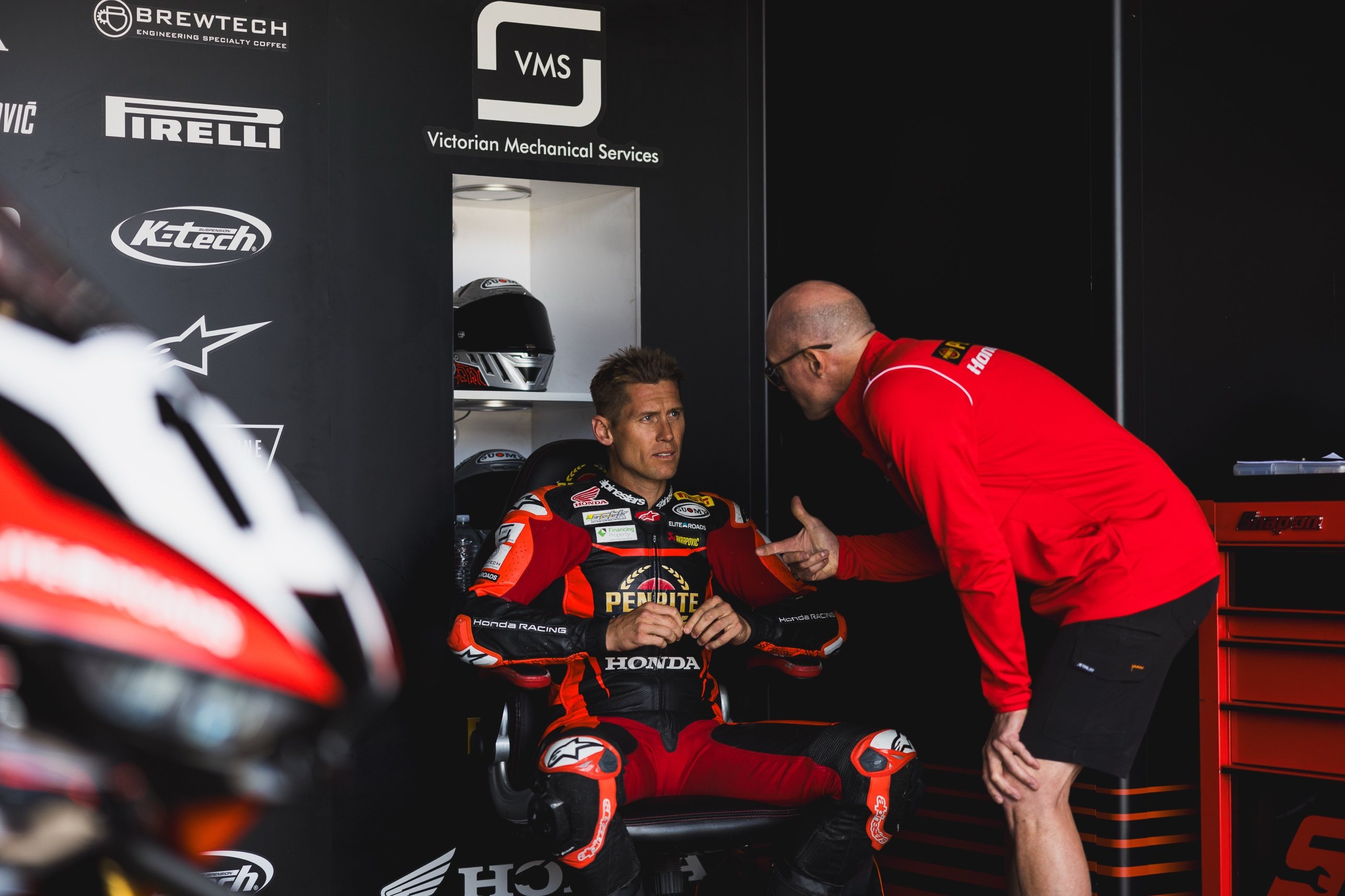 Troy Herfoss in a garage debrief with his crew during a superbike race weekend